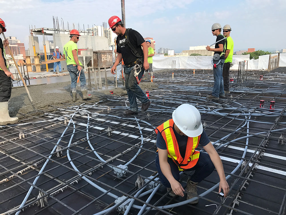 Workers installing SmartRock sensors on rebar grid
